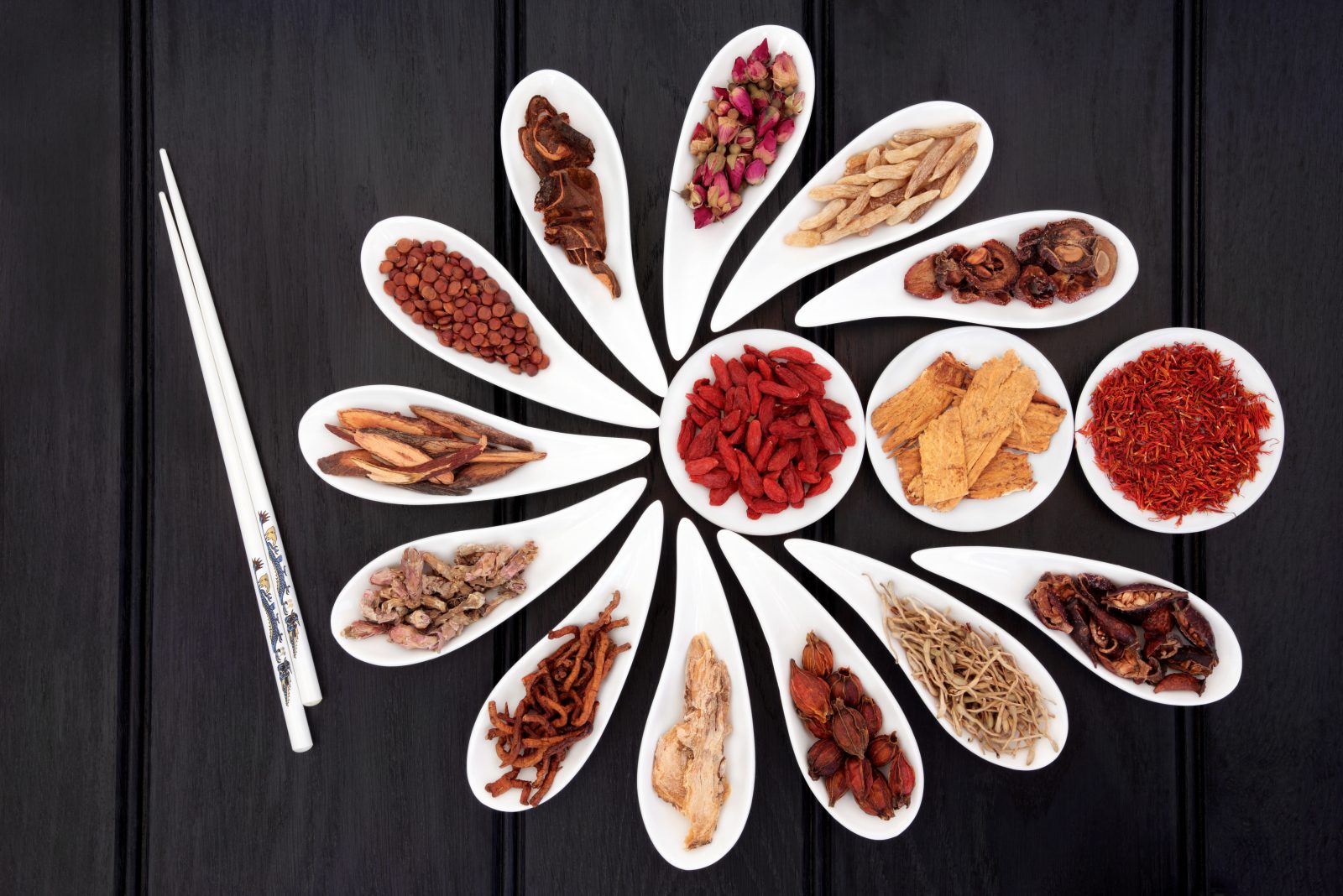 Chinese herbal medicine selection in white china bowls with chopsticks.
